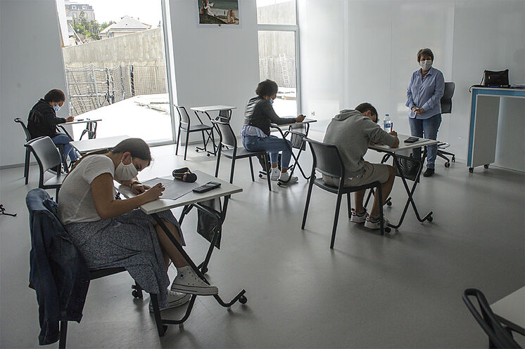 Alumnos con mascarillas reciben clase durante la desescalada, en un...