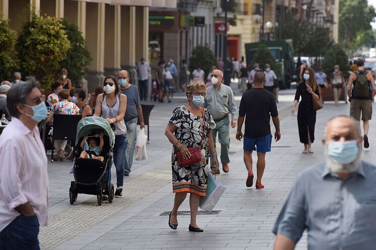 Plusieurs personnes avec des masques se promènent dans les rues de Huesca.