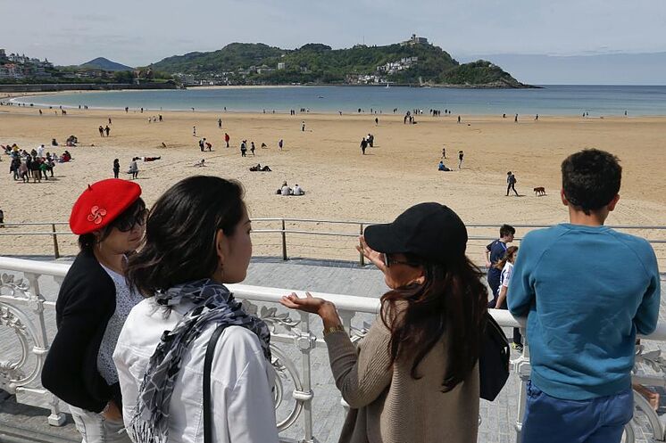 Un groupe de touristes observe la plage de La Concha à San Sebasti