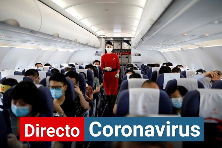 Un agent de bord marche dans un avion rempli de passagers dans un aéroport ...