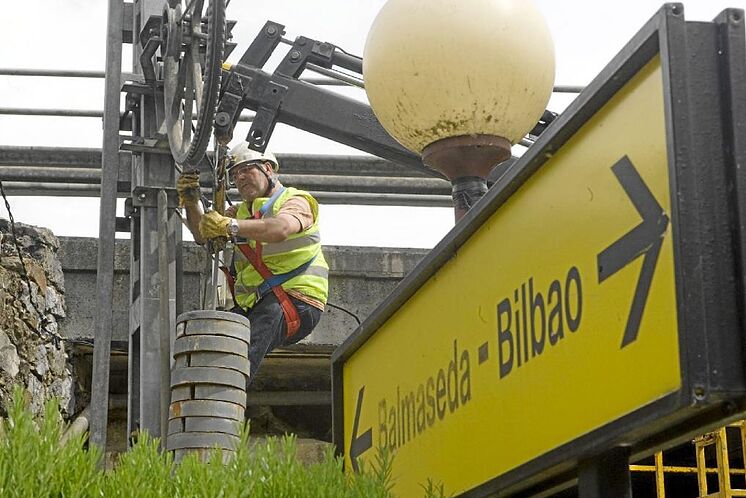 Deux opérateurs fixent la caténaire d'un v
