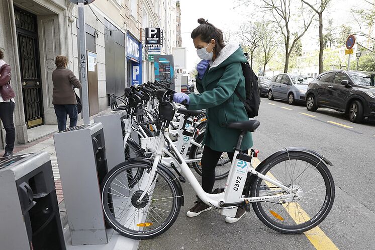 Une jeune femme tire un vélo d'une station