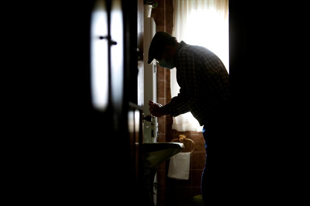 Un vieil homme se lave les mains dans sa maison du conseil de Coru