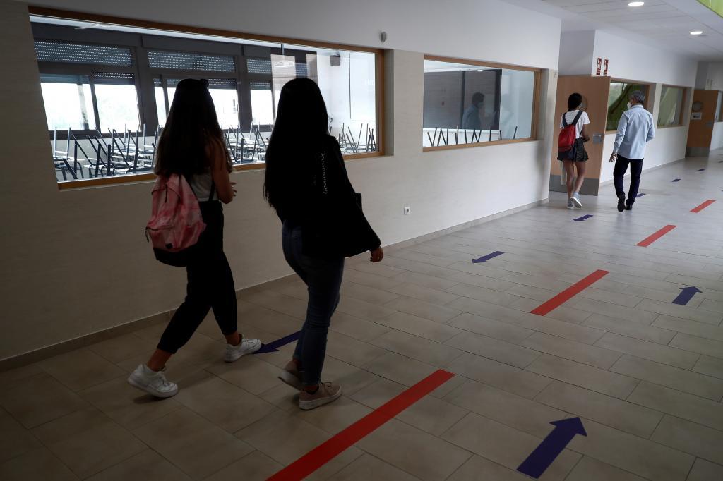 Les lycéens vont en classe dans un couloir séparé par des flèches.