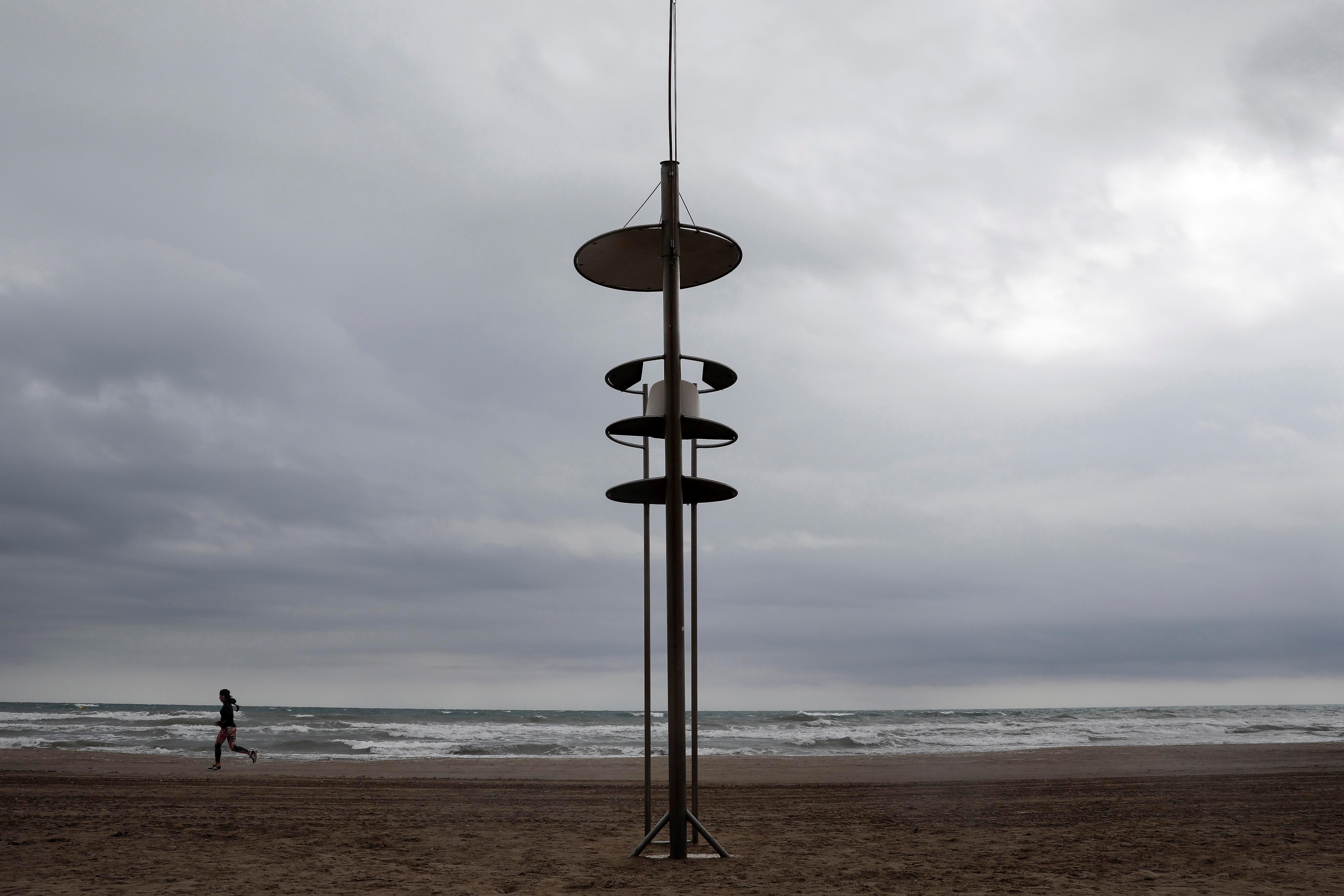 Une personne court sur la plage de Valence.