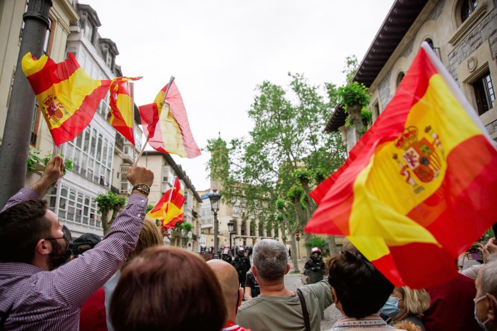 Plusieurs personnes agitent des drapeaux de l'Espagne