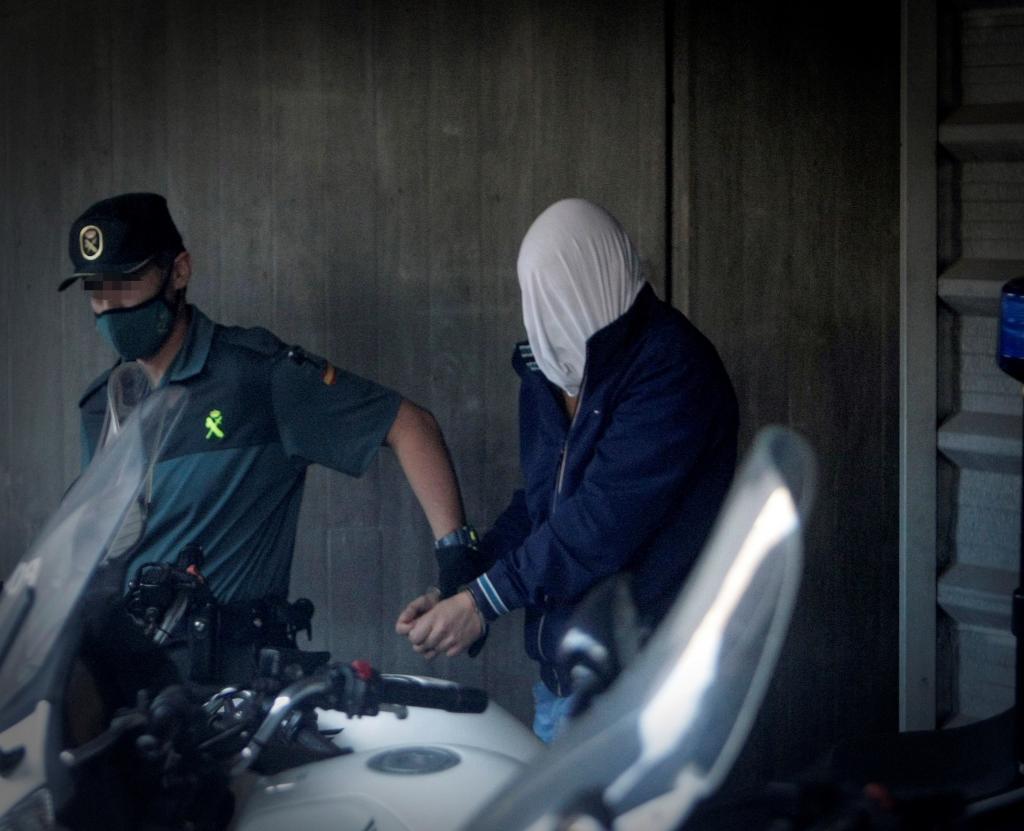 Un garde civil déplace l'un des meurtriers présumés de Samuel Luiz, le visage caché.