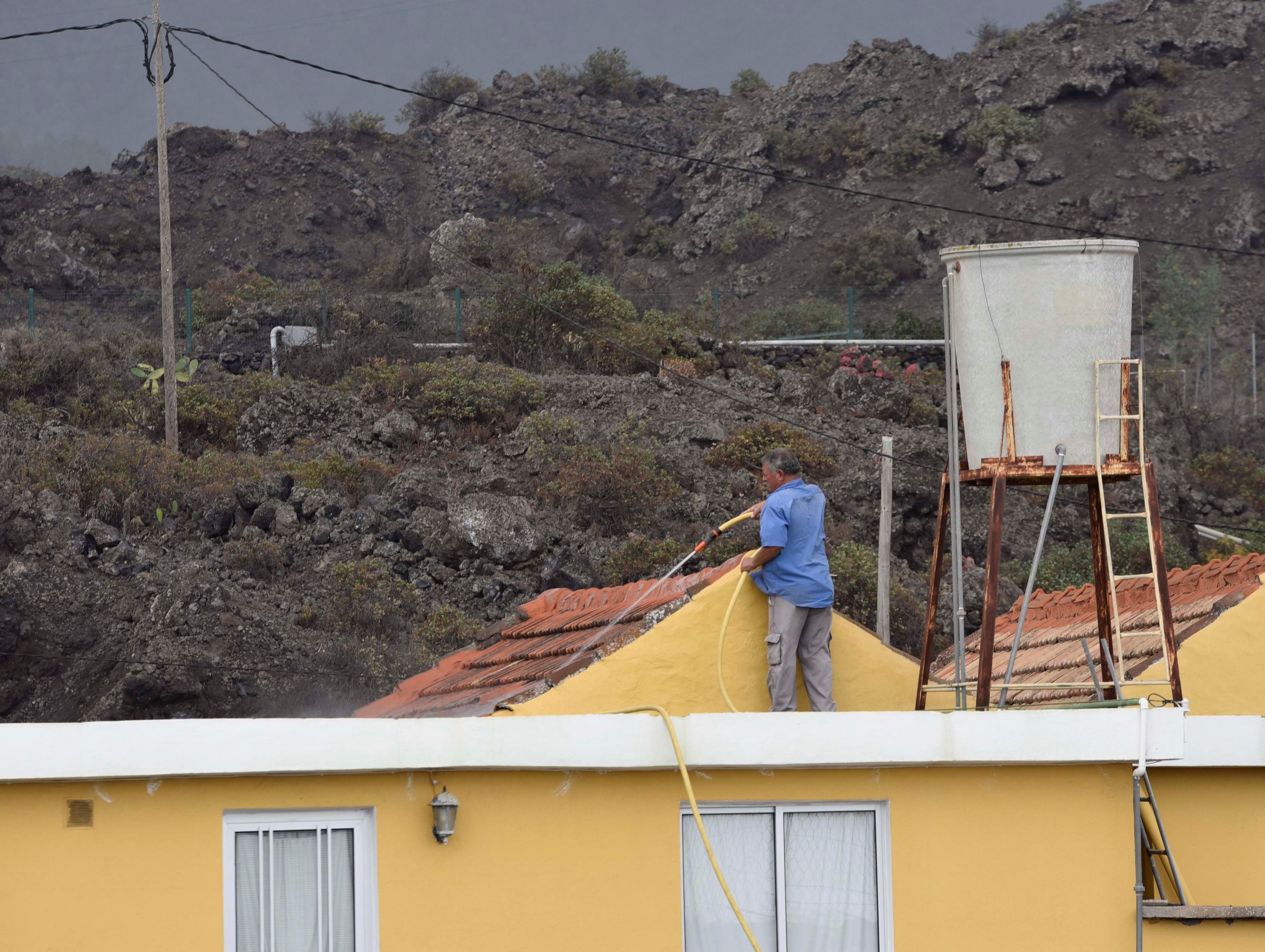 Un voisin de Tacande nettoie le toit de sa maison touchée par la ca