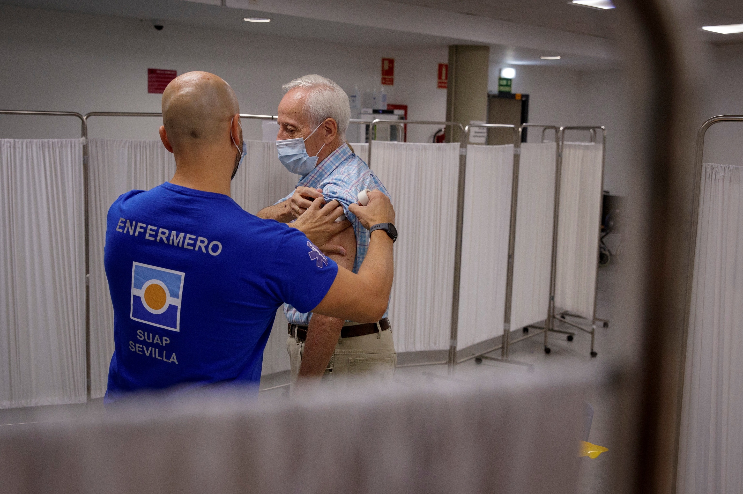 Une infirmière inocule la troisième dose du vaccin Covid à un homme de plus de 70 ans