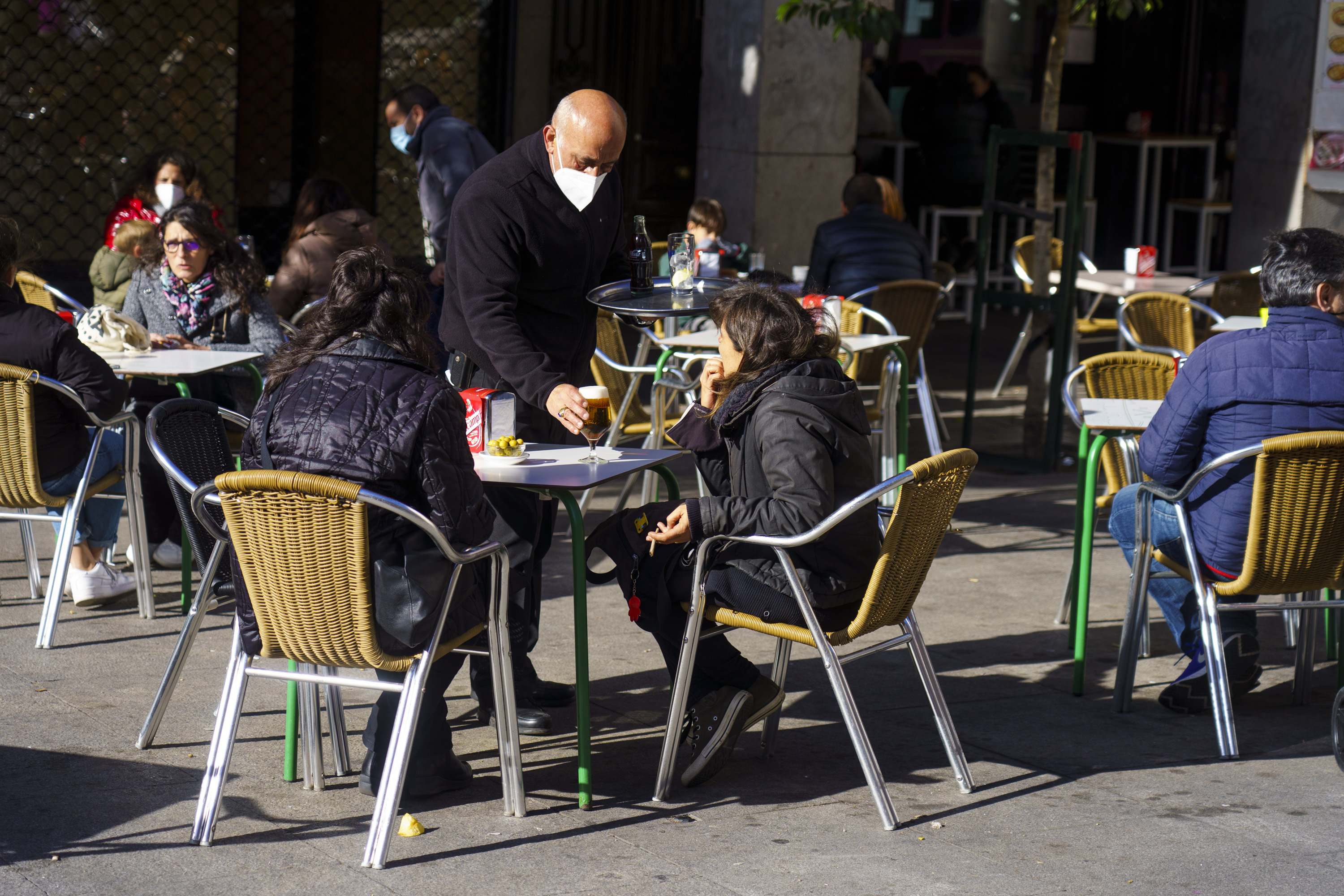 Plusieurs personnes, en terrasse à Madrid en décembre.