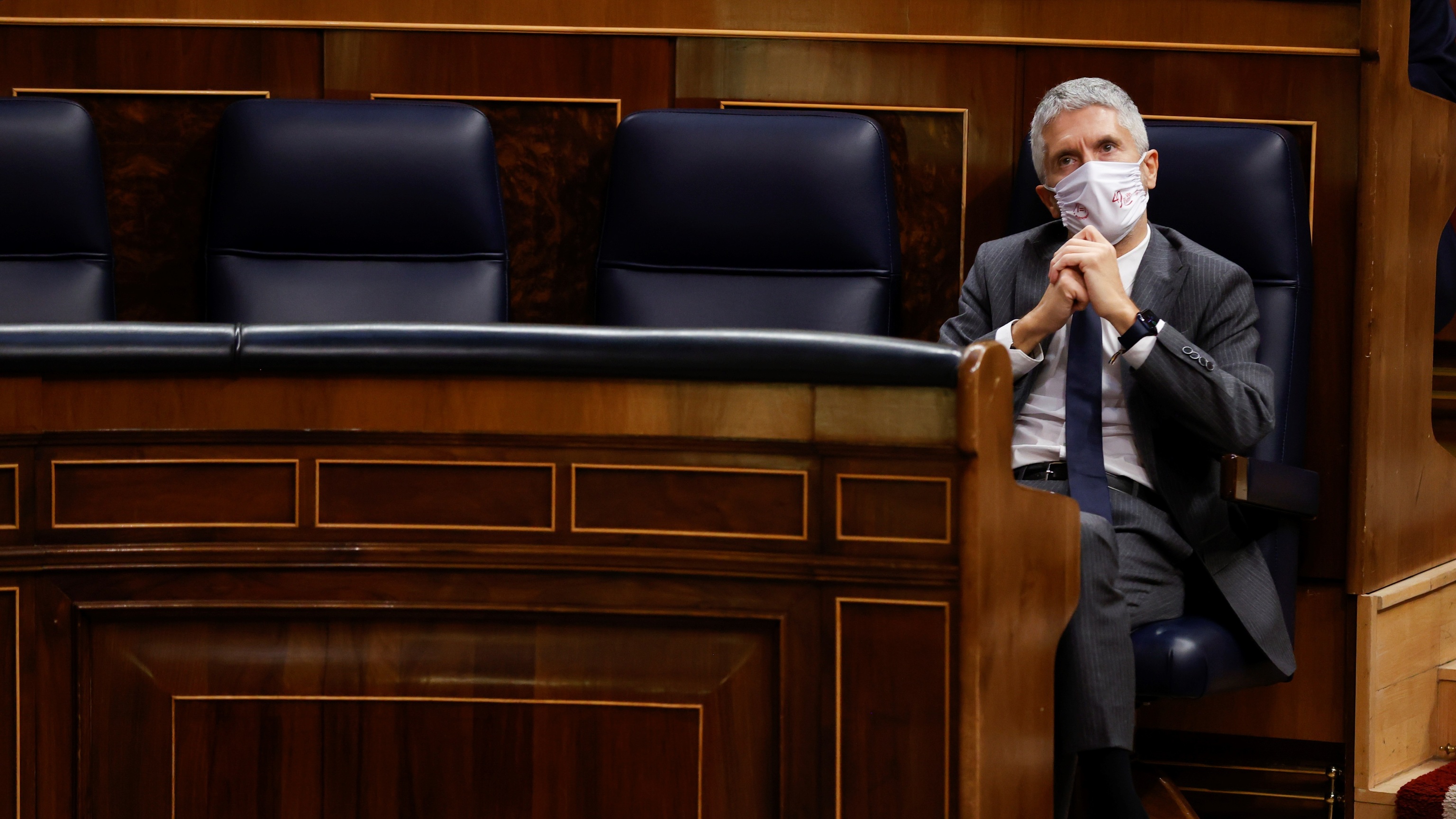 Le ministre Grande-Marlaska, pensif, à son siège lors d'une séance de contrôle au Congrès des députés.
