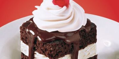 Shoney&rsquo;s brille avec son engagement annuel à offrir à l&rsquo;Amérique sa journée GRATUITE du gâteau au fudge chaud, avec de la crème glacée à la vanille au milieu de deux tranches de gâteau au fudge chaud – garnies de crème fouettée et d&rsquo;une cerise