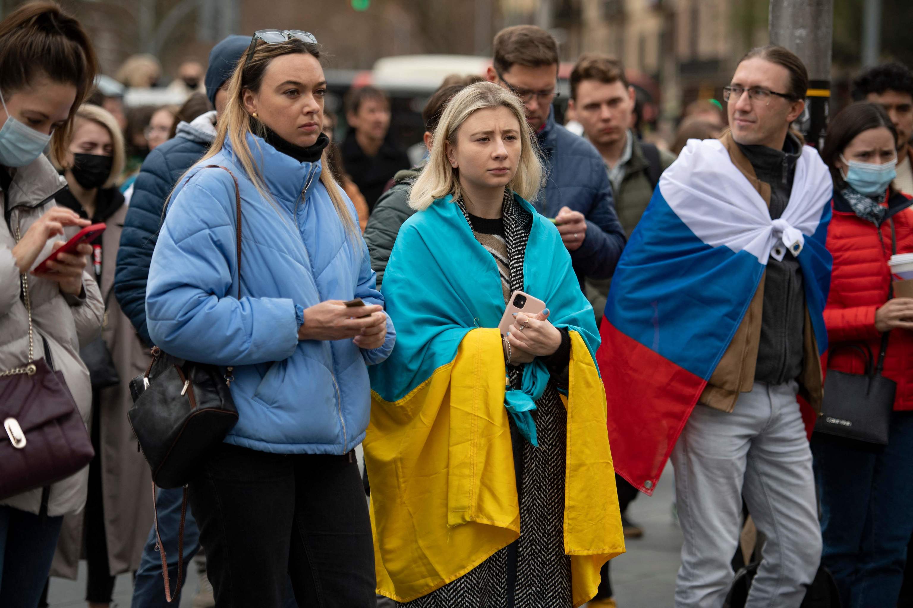 Des manifestants portent un drapeau ukrainien et un drapeau russe lors d'une manifestation contre l'opération