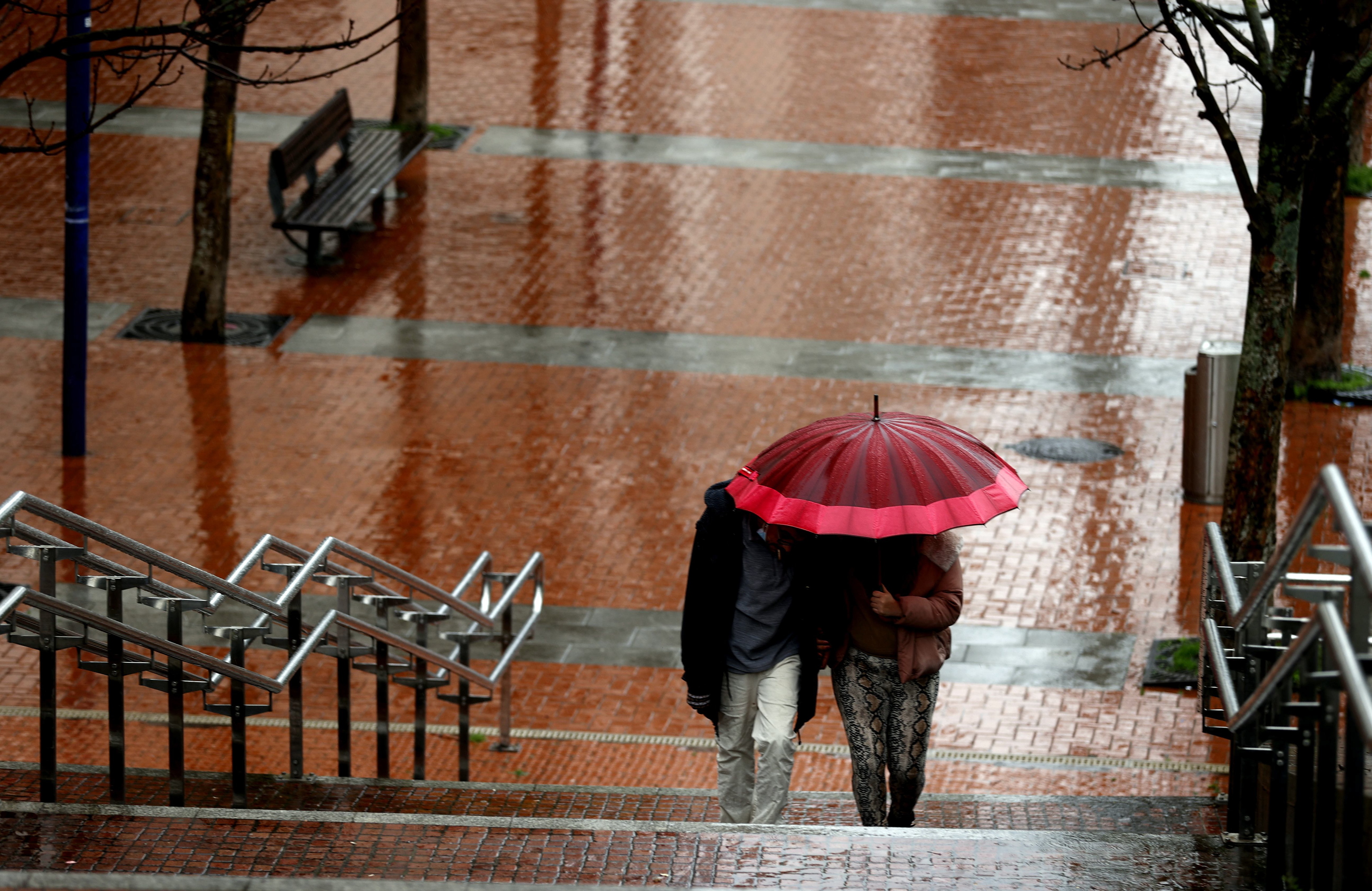 Deux personnes se protègent de l'eau avec un parapluie ce jeudi à Bilbao.  Après quelques mois avec peu de pluie et avec très c