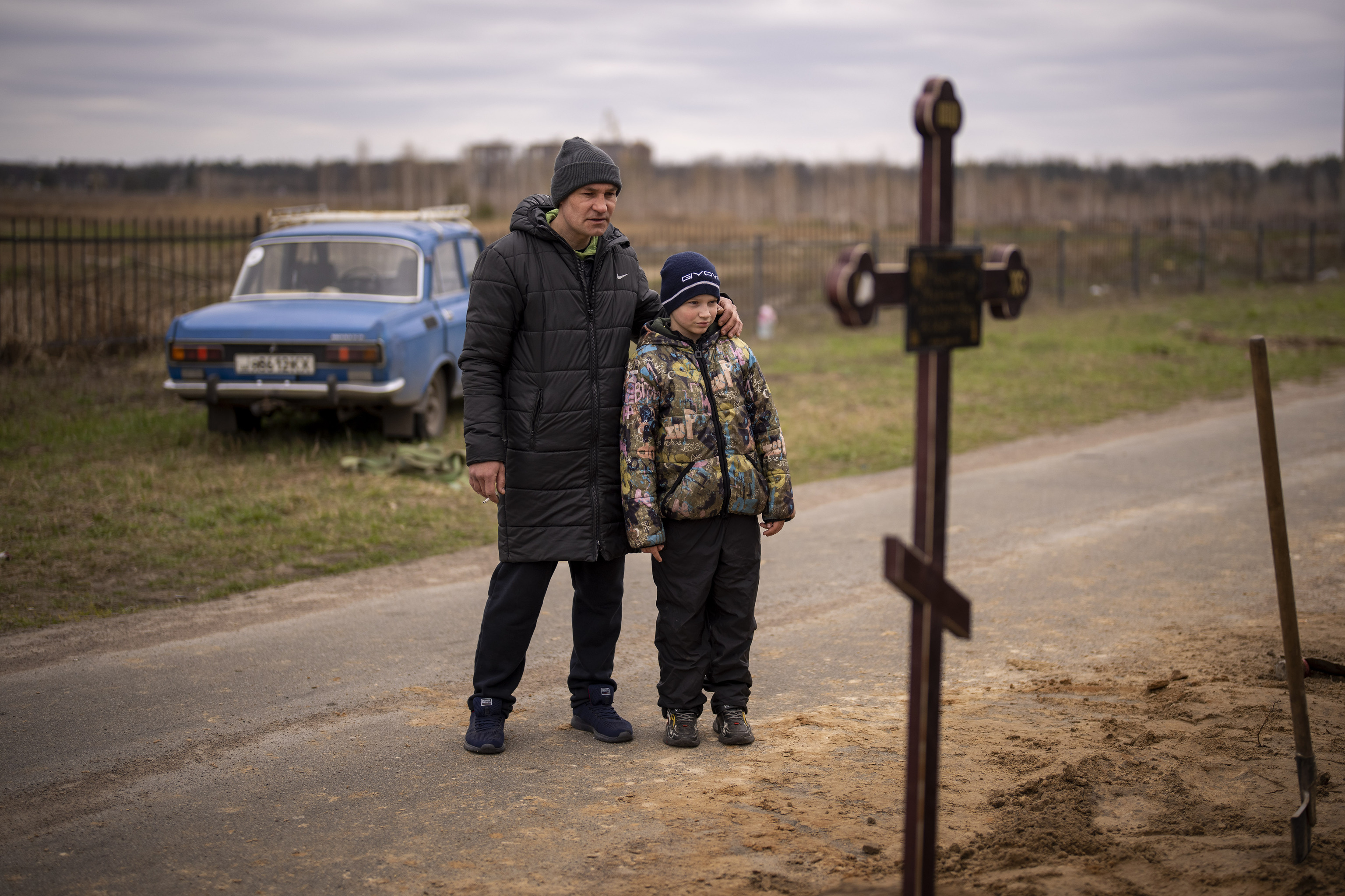 Père et fils assistent aux funérailles de leur mère et de leur femme à Bucha.
