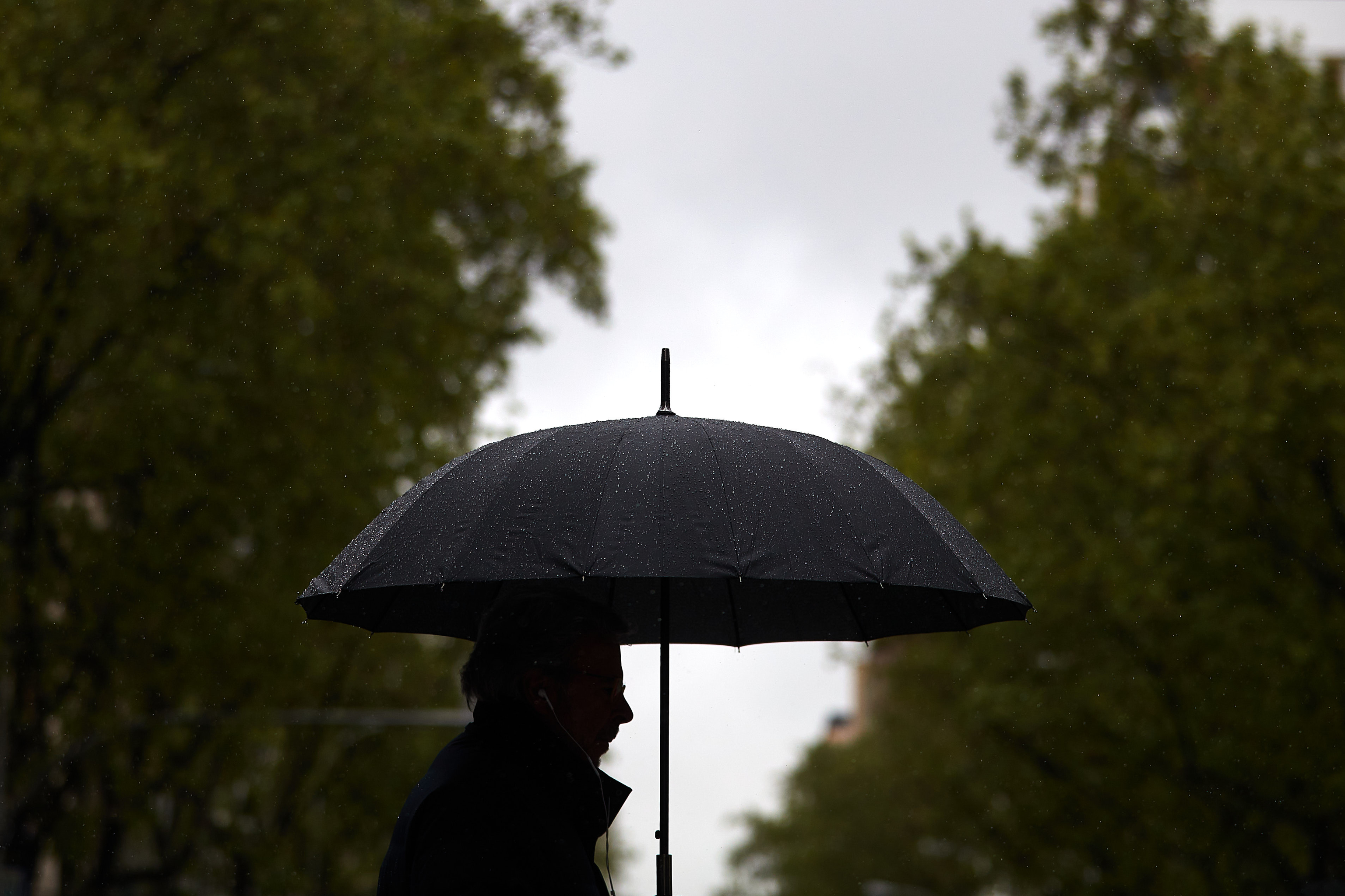 Un homme se protège de la pluie.