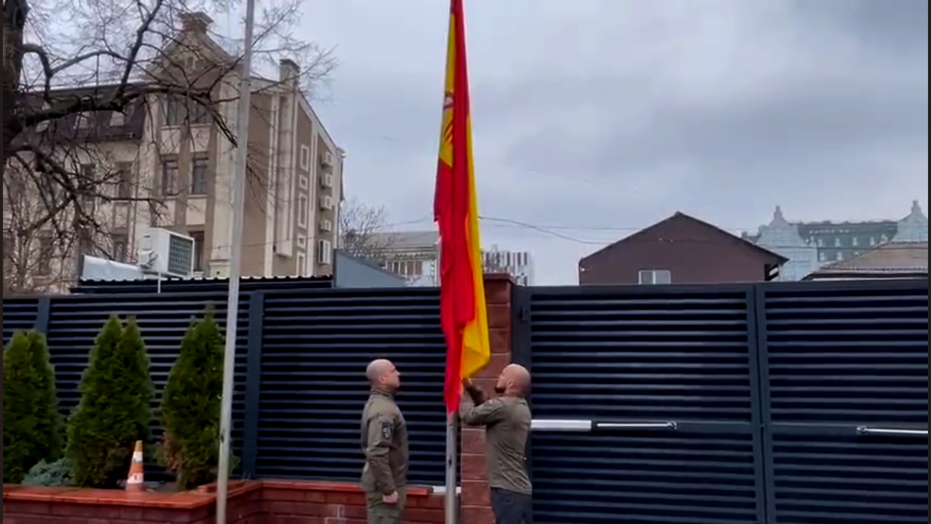 Deux agents de Geos hissent le drapeau à l'ambassade d'Espagne