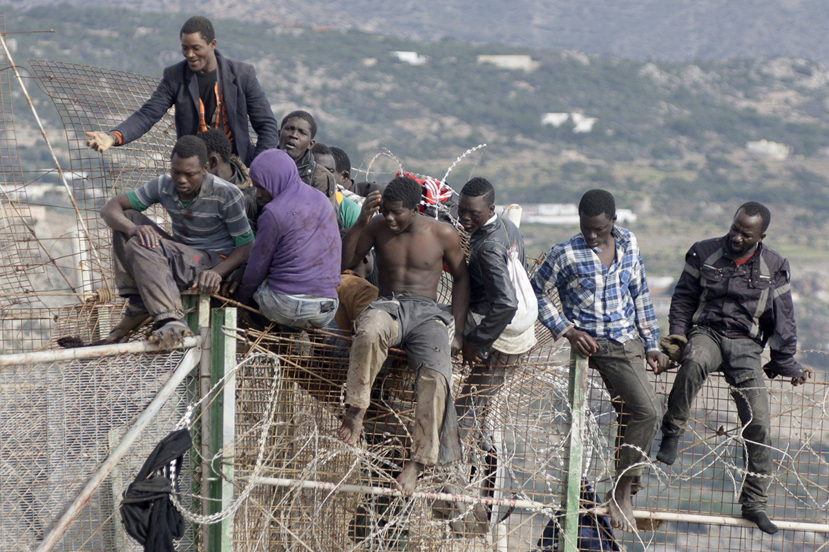Immigrants sautant la clôture de Melilla.