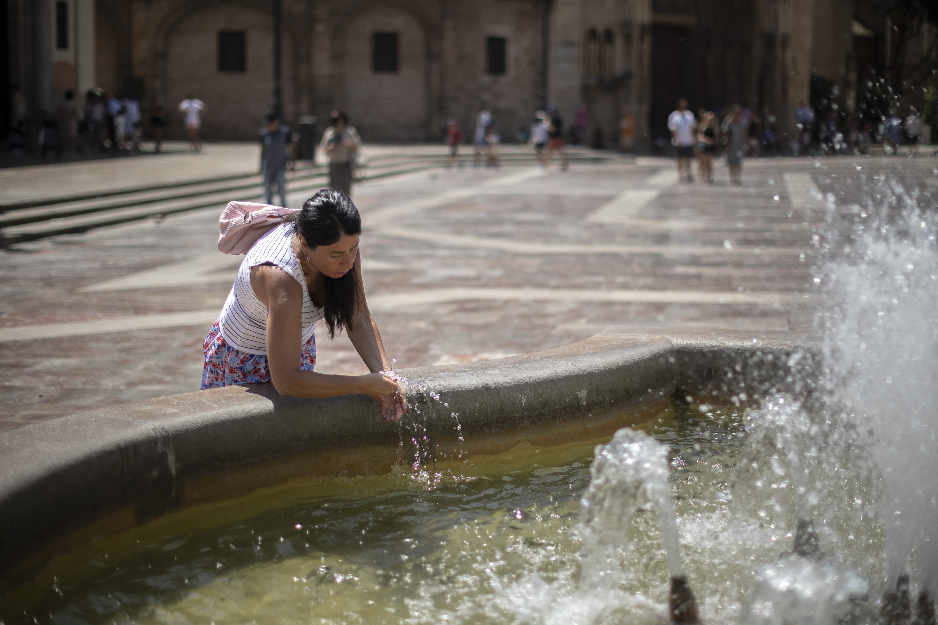 Une femme se rafraîchit dans une fontaine à Valence.