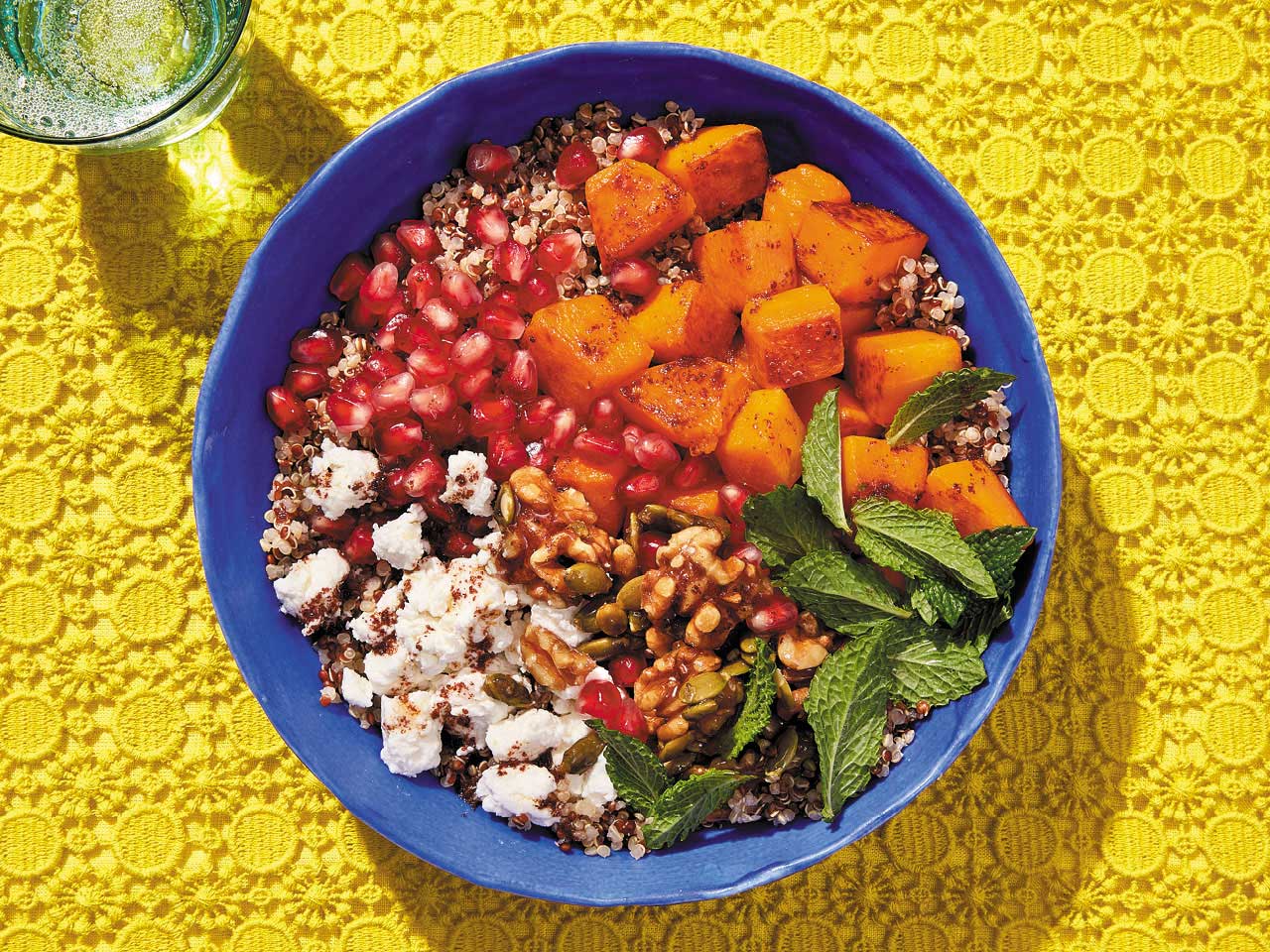Salade de courge rôtie et de quinoa servie sur une assiette bleue