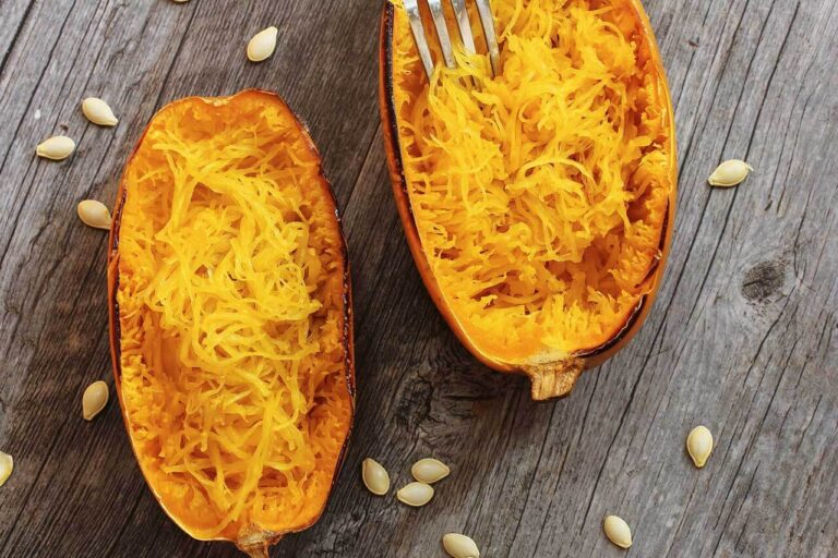 Roasted spaghetti squash served on a rustic wooden table, with its golden strands and caramelized edges.