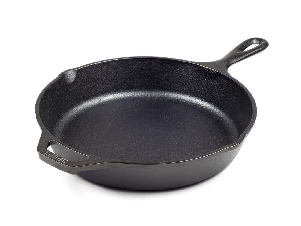 Une poêle en fonte Lodge de 10 pouces sur fond blanc, pour illustrer un article sur la façon de cuisiner un steak parfait à l'intérieur.