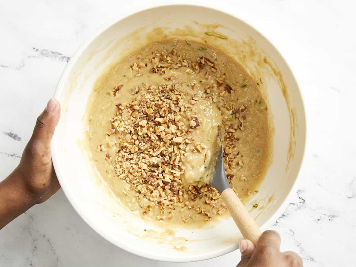 Noix hachées ajoutées à la pâte à pain aux courgettes.