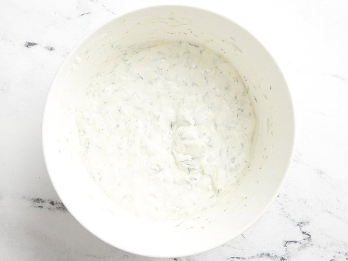 Sauce tzatziki dans un bol de service blanc.