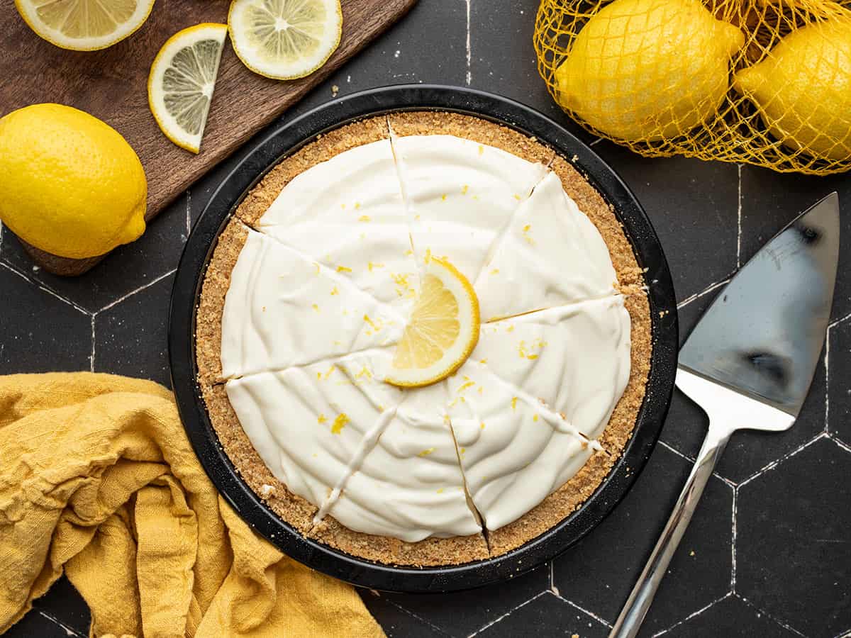 Vue aérienne d'une tarte à la crème au citron coupée en tranches avec des citrons sur les côtés