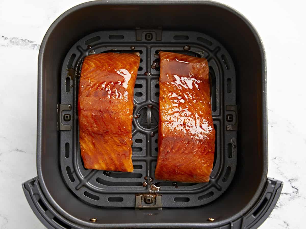 Filets de saumon marinés dans un panier de friteuse à air.