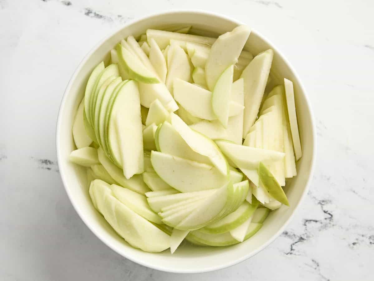 Pommes Granny Smith tranchées dans un bol à mélanger.
