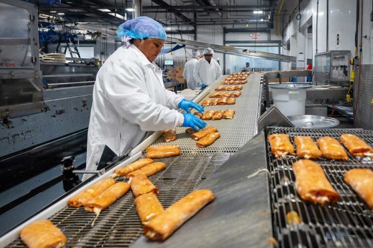 L'emballage robotisé permet d'économiser du travail dans l'usine de garniture de pizza de Great Kitchens