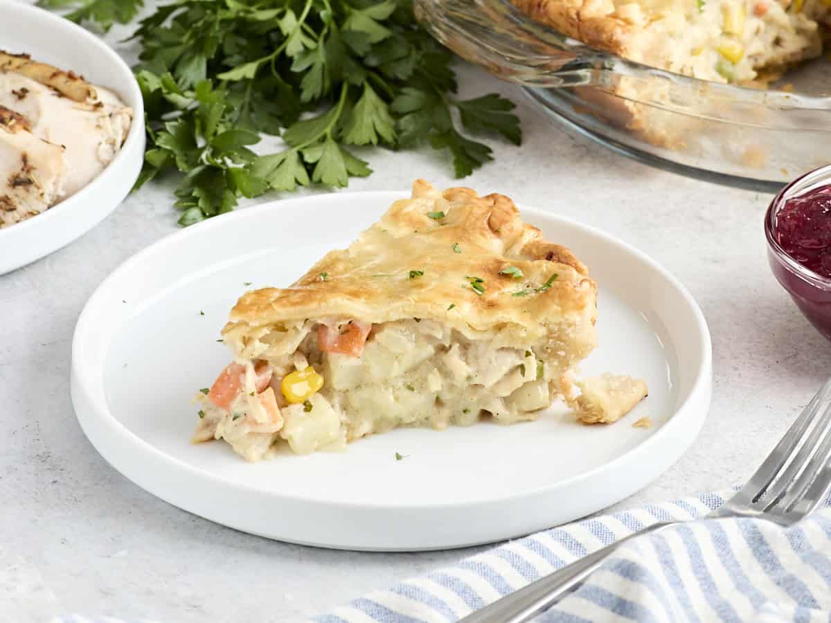 Vue latérale d'une tranche de tourte à la dinde sur une assiette.