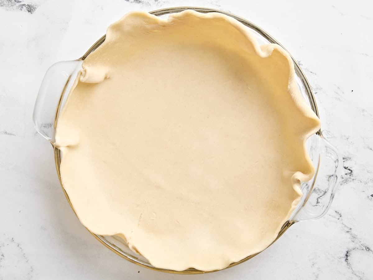 Une croûte à tarte étalée dans un plat à tarte.