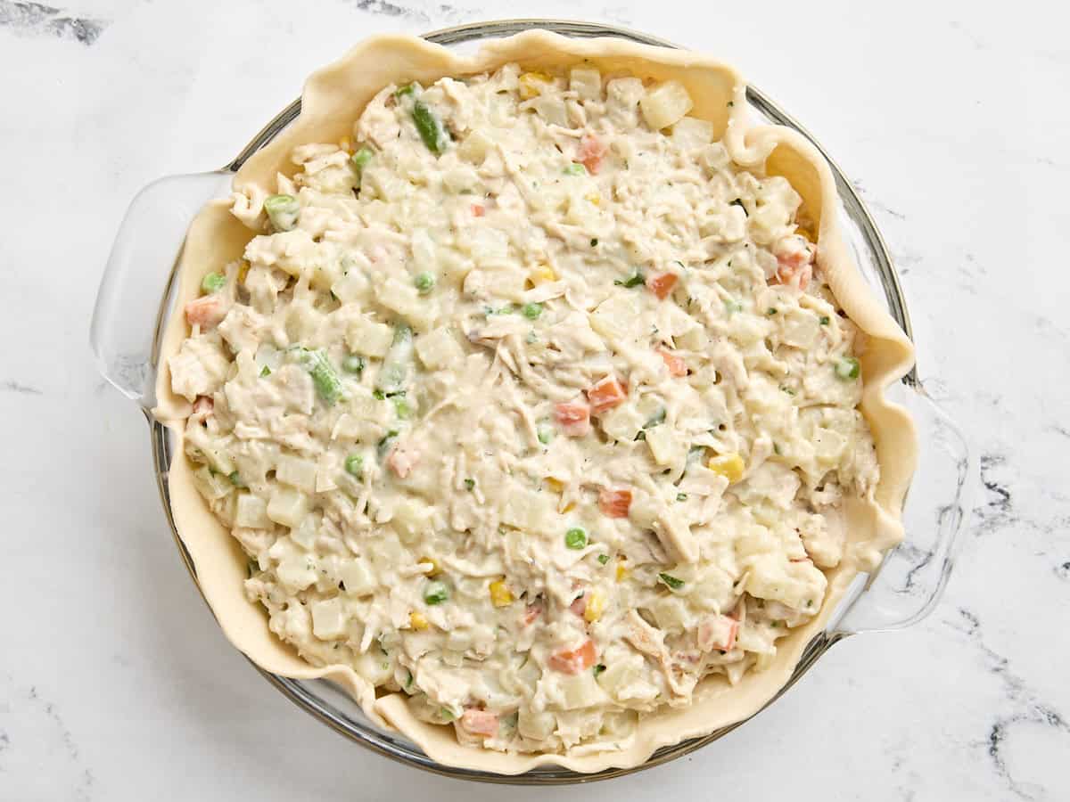 Garniture pour tourte à la dinde ajoutée à la croûte étalée dans un moule à tarte.