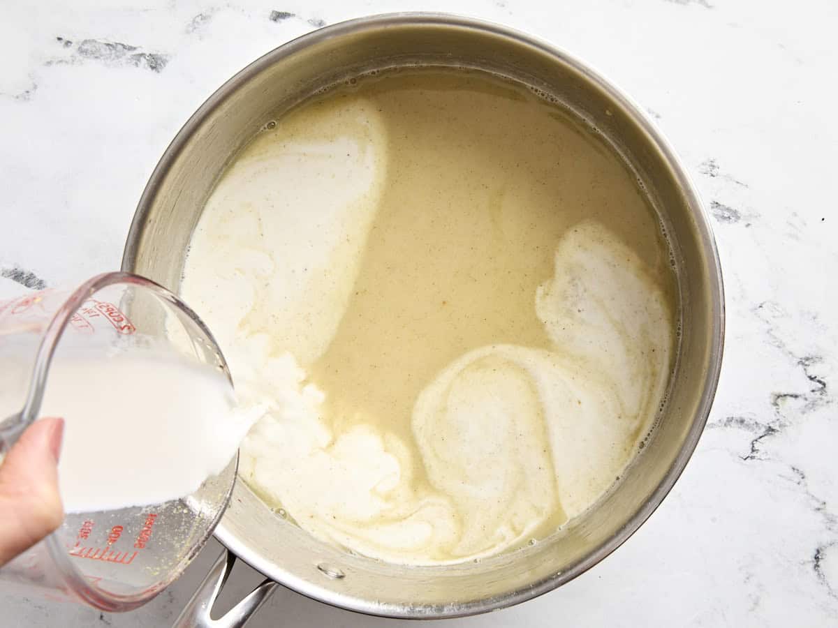Moitié-moitié ajoutée à la sauce crémeuse pour pâté à la dinde dans une casserole.