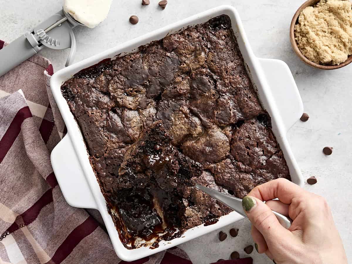 Vue aérienne d'une cuillère sortant du gâteau au pouding au chocolat d'un moule à gâteau.