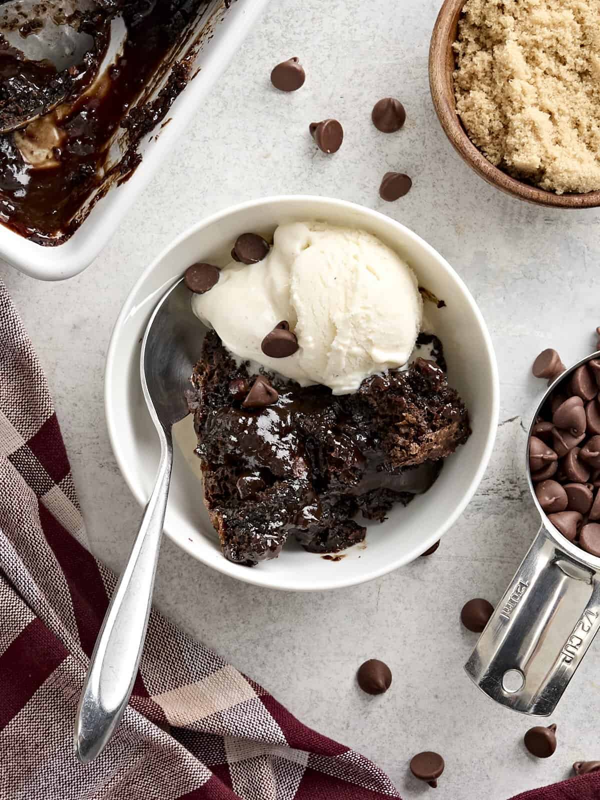 Vue aérienne d'une tranche de gâteau au pouding au chocolat dans un bol avec de la glace à la vanille.