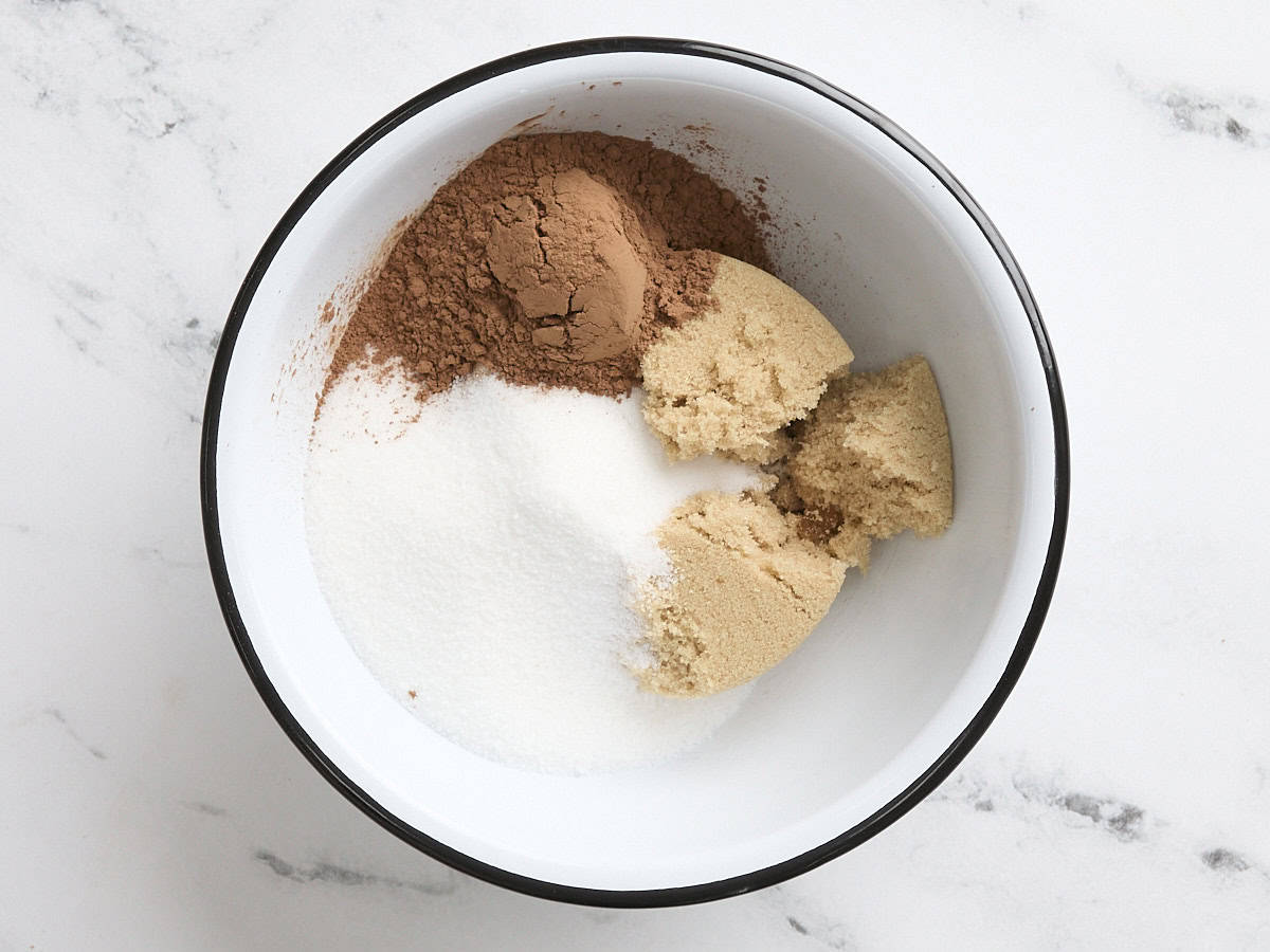 Sucre cristallisé, cassonade. et le cacao en poudre dans un bol à mélanger.