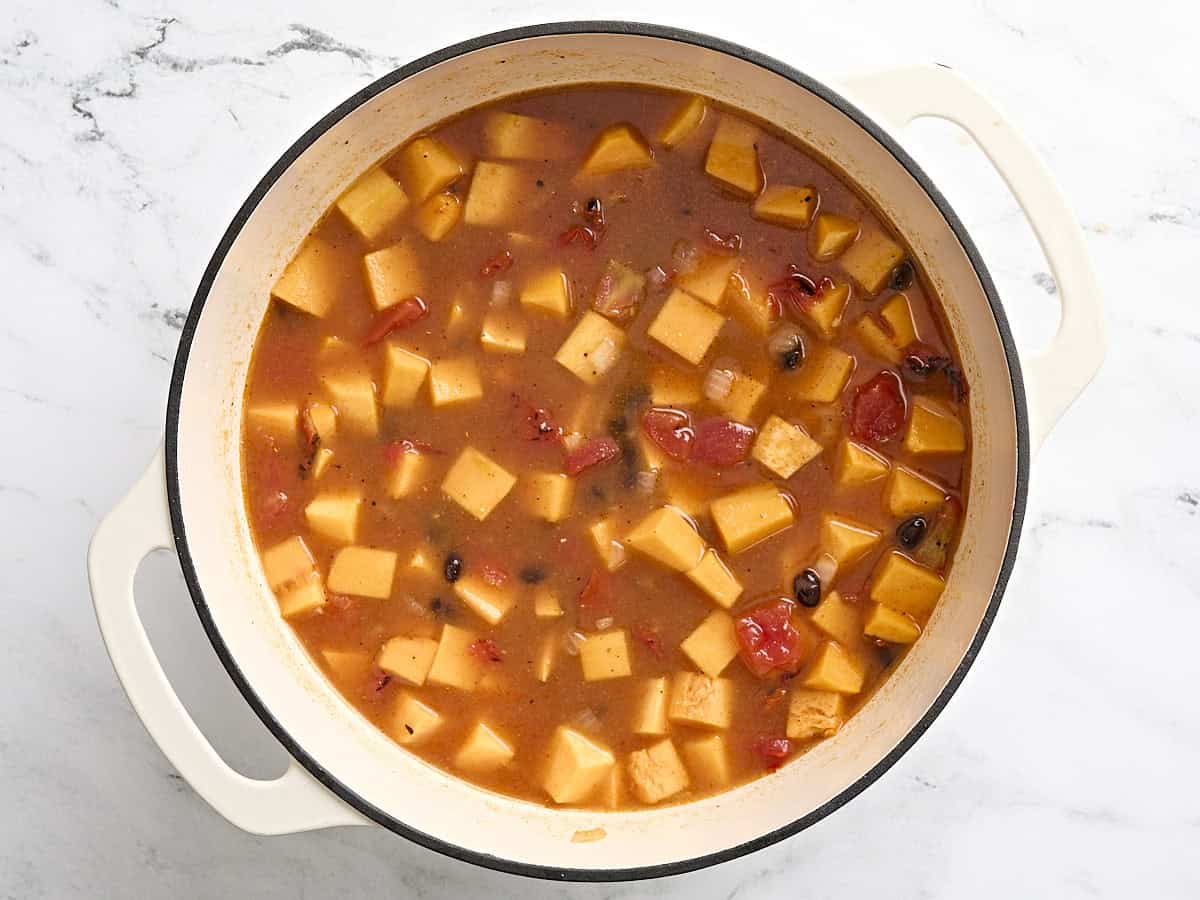 Soupe de courge musquée et haricots noirs à mi-cuisson au four hollandais.