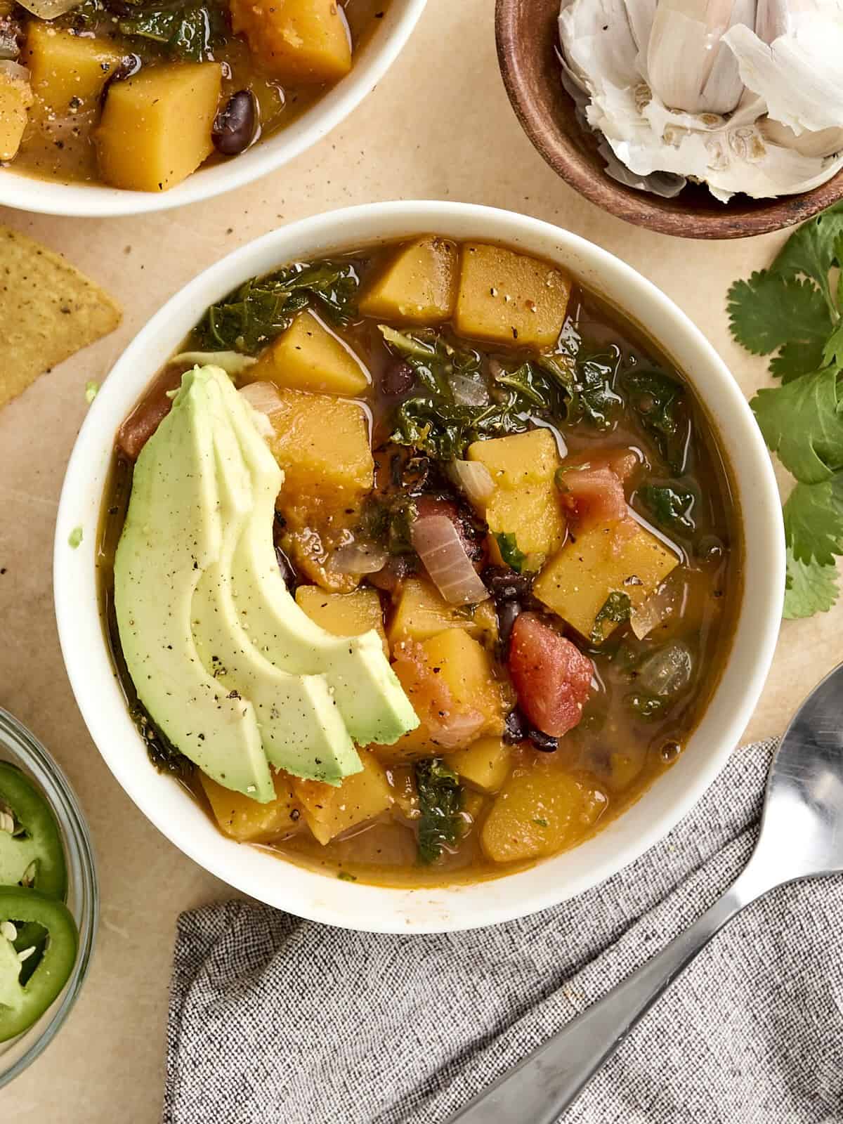 Vue aérienne d'un bol de courge musquée avec une soupe de haricots noirs, garnie d'avocat.