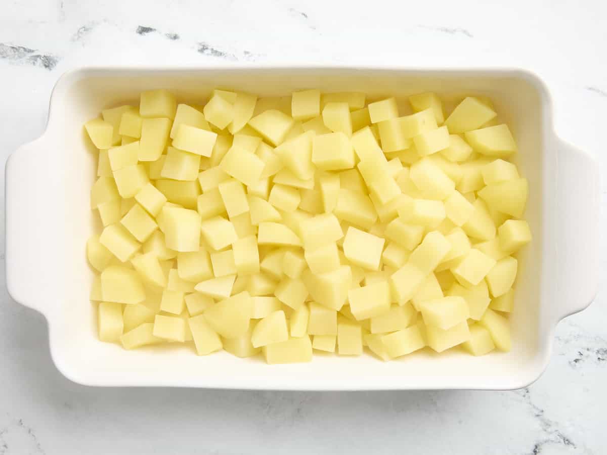 Pommes de terre coupées en dés ajoutées à une cocotte.