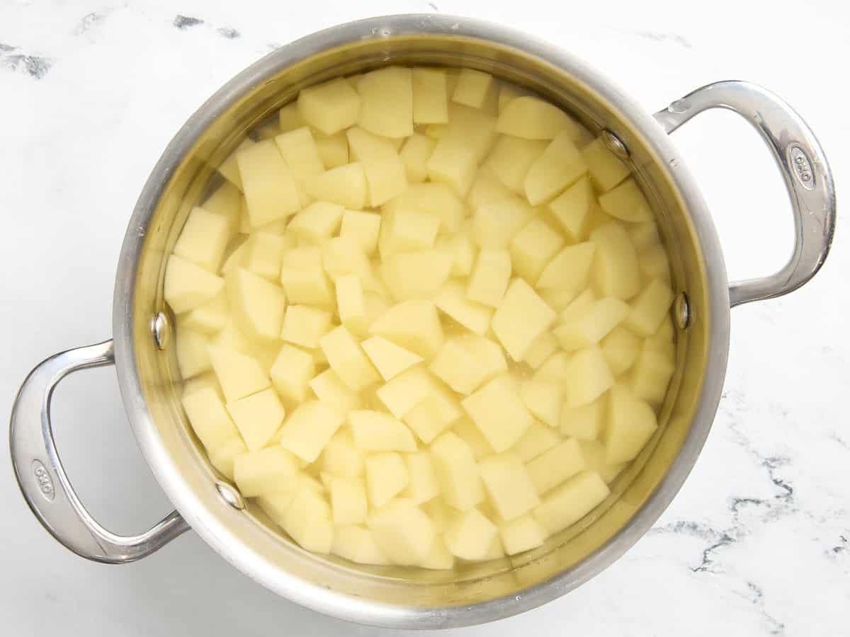 Coupez les pommes de terre en dés dans une casserole d'eau.