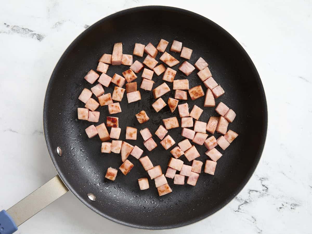 Steak de jambon coupé en dés dans une poêle.