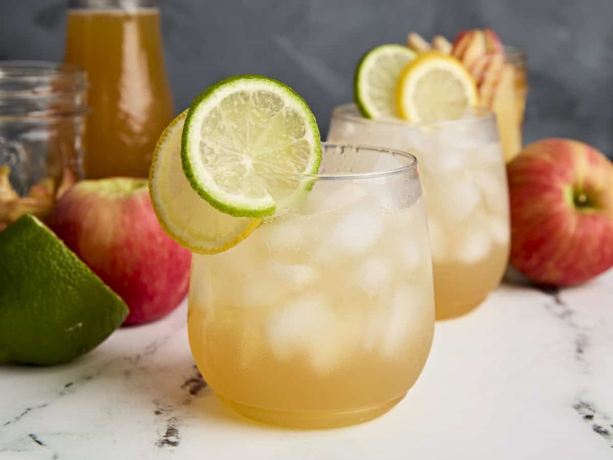 Vue latérale du cocktail sans alcool au cidre de pomme et au citron vert pour la garniture.