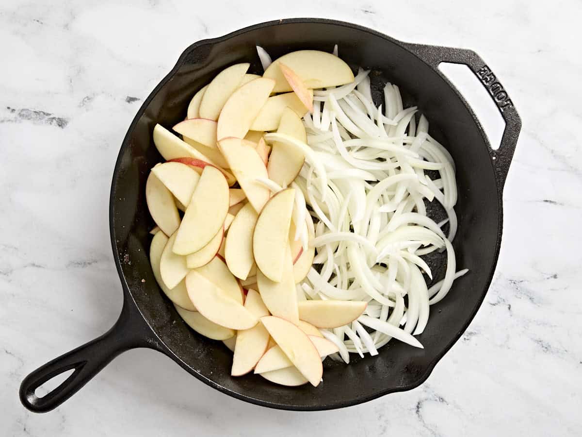 Pommes et oignons tranchés dans une poêle.