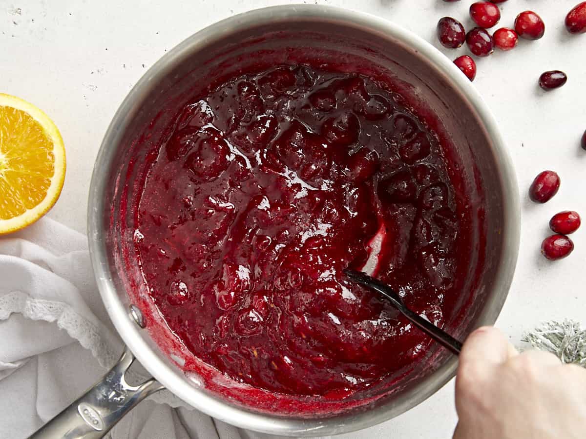 Cette simple sauce aux canneberges classique ne nécessite que trois ingrédients mais a suffisamment de saveur pour ajouter du piquant à votre repas des Fêtes. Budgetbytes.com Sauce aux canneberges épaissie dans la casserole en remuant.