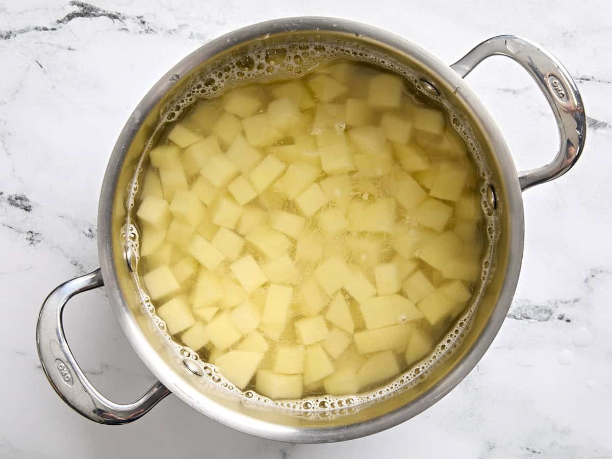 Pommes de terre coupées en dés dans une casserole d'eau.