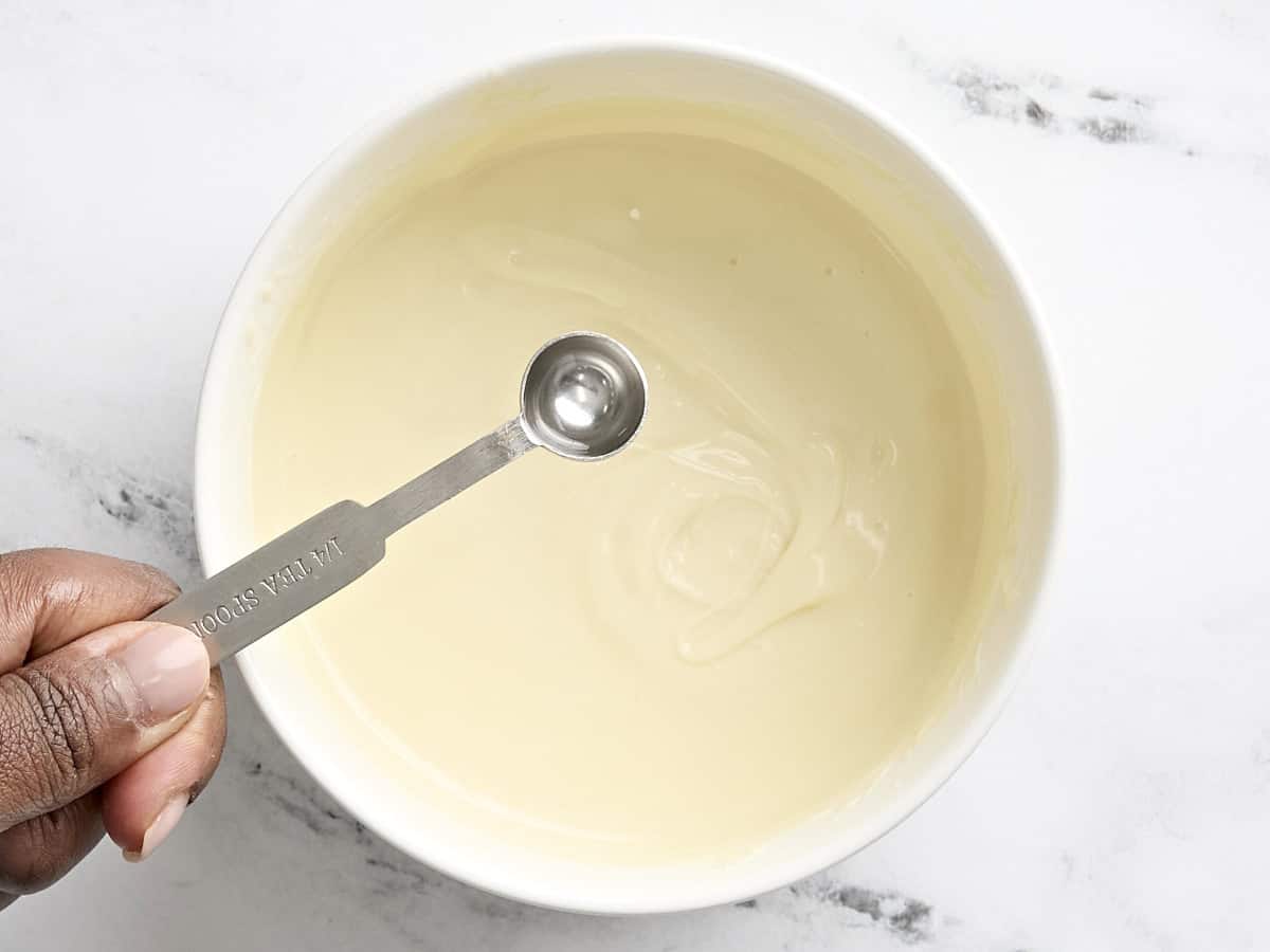Extrait de menthe poivrée ajouté à un bol de chocolat fondu.