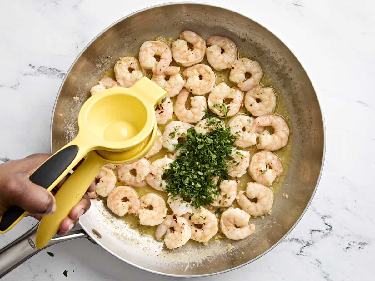 Un demi-citron pressé dans des langoustines aux crevettes, avec du persil frais ajouté.